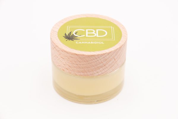 Pot de Baume Relaxant CBD Bio MONPLANCBD avec couvercle en bois et étiquette verte "CBD Cannabidiol".