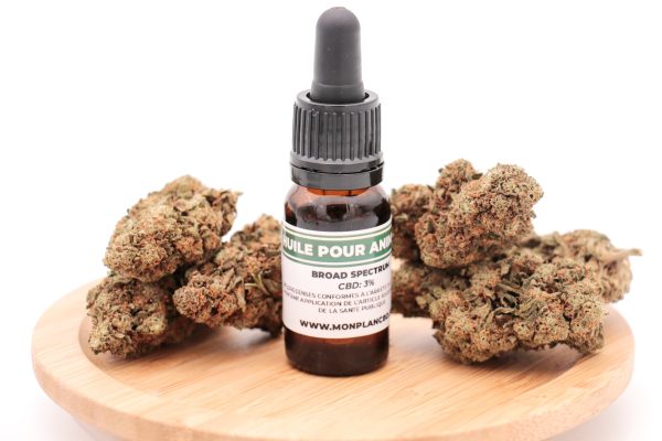 Flacon Huile CBD 3% pour Animaux MONPLANCBD sur socle bois avec têtes de chanvre - CBD pour chien et chat.