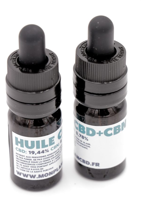 Deux flacons d'Huile CBD+CBN Broad Spectrum MONPLANCBD (qualité Suisse) parmi des têtes de chanvre - Huile CBD pour sommeil.
