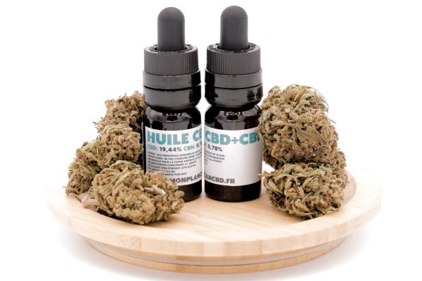 Deux flacons d'Huile CBD 20% + CBN 9% MONPLANCBD (10ml) sur socle en bois avec têtes de chanvre - Huile CBD CBN sommeil.
