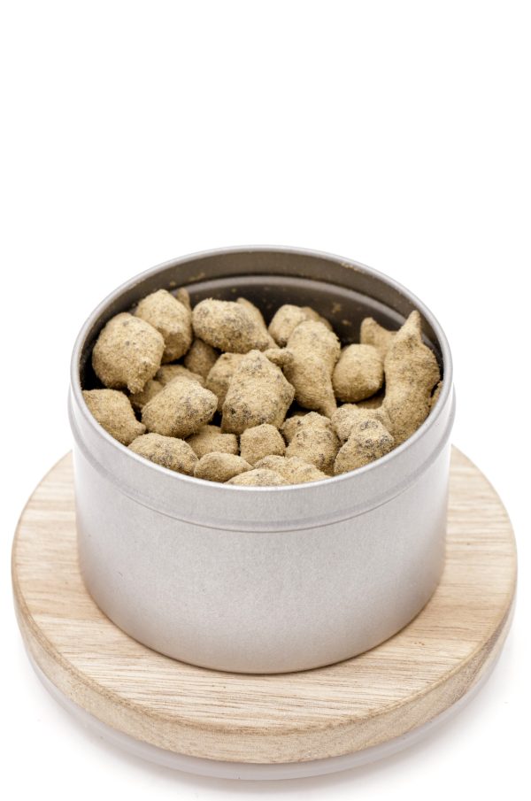Boîte métallique MONPLANCBD ouverte remplie de Moonrocks CBD 45%, posée sur un socle en bois - CBD à vendre.